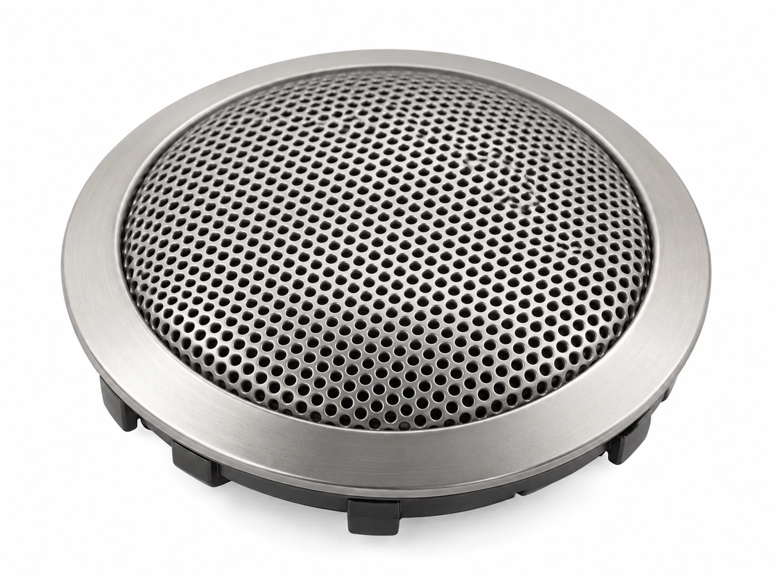 Close-up of a small round fine-perforated satin metal tweeter grille on a car A-pillar trim near the windscreen