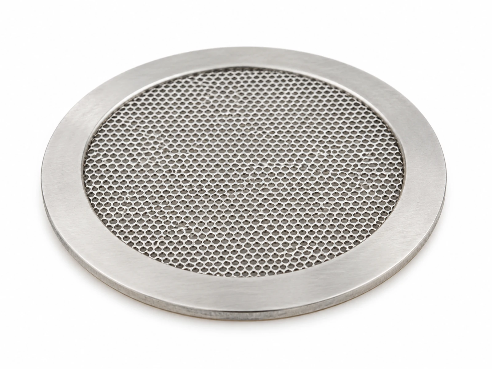 A small round etched stainless steel vent mesh patch with adhesive ring on the back of an automotive LED headlamp housing