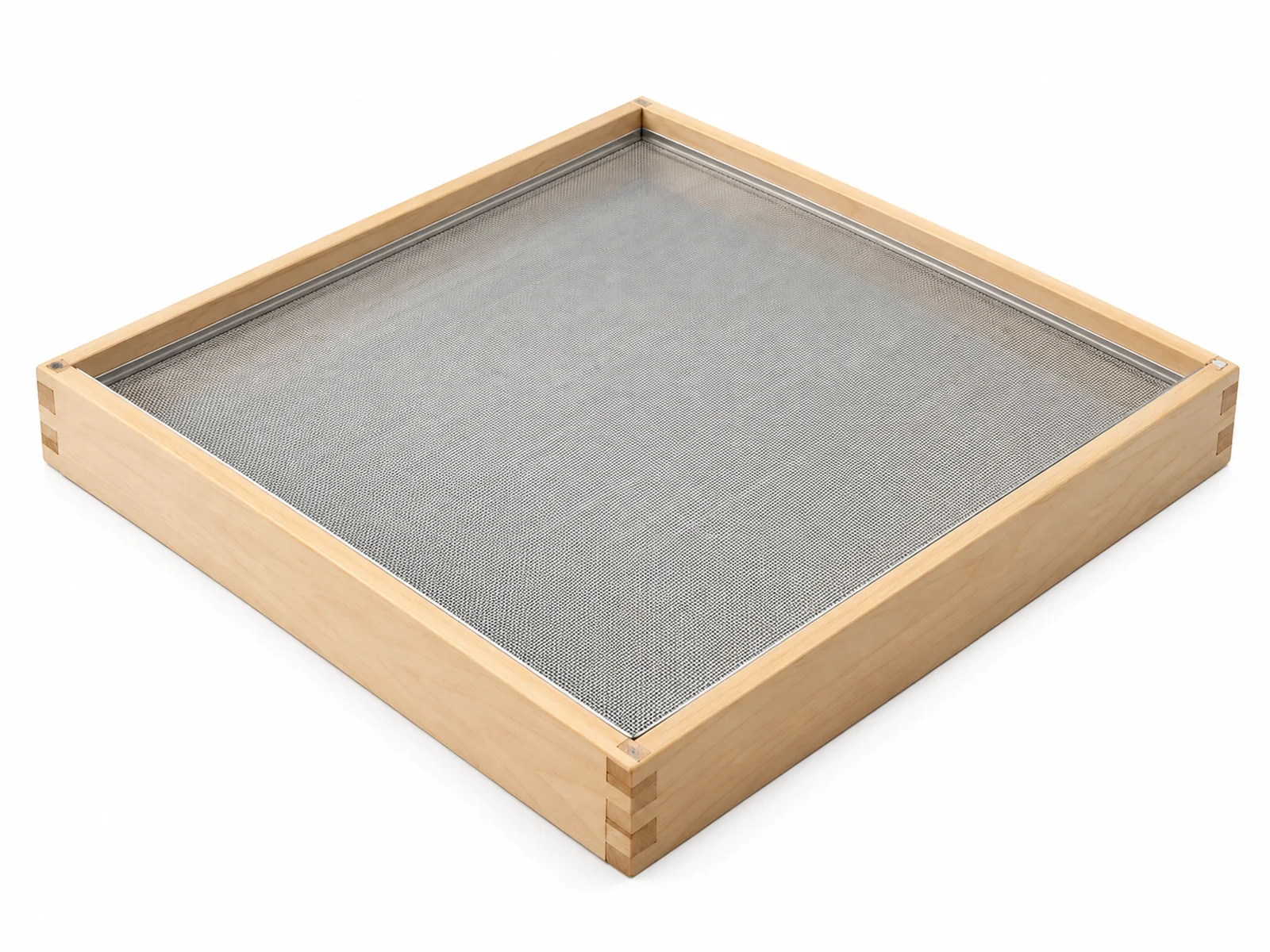 A square wooden plansifter sieve frame with tensioned stainless steel mesh on a flour mill workbench, light flour dust