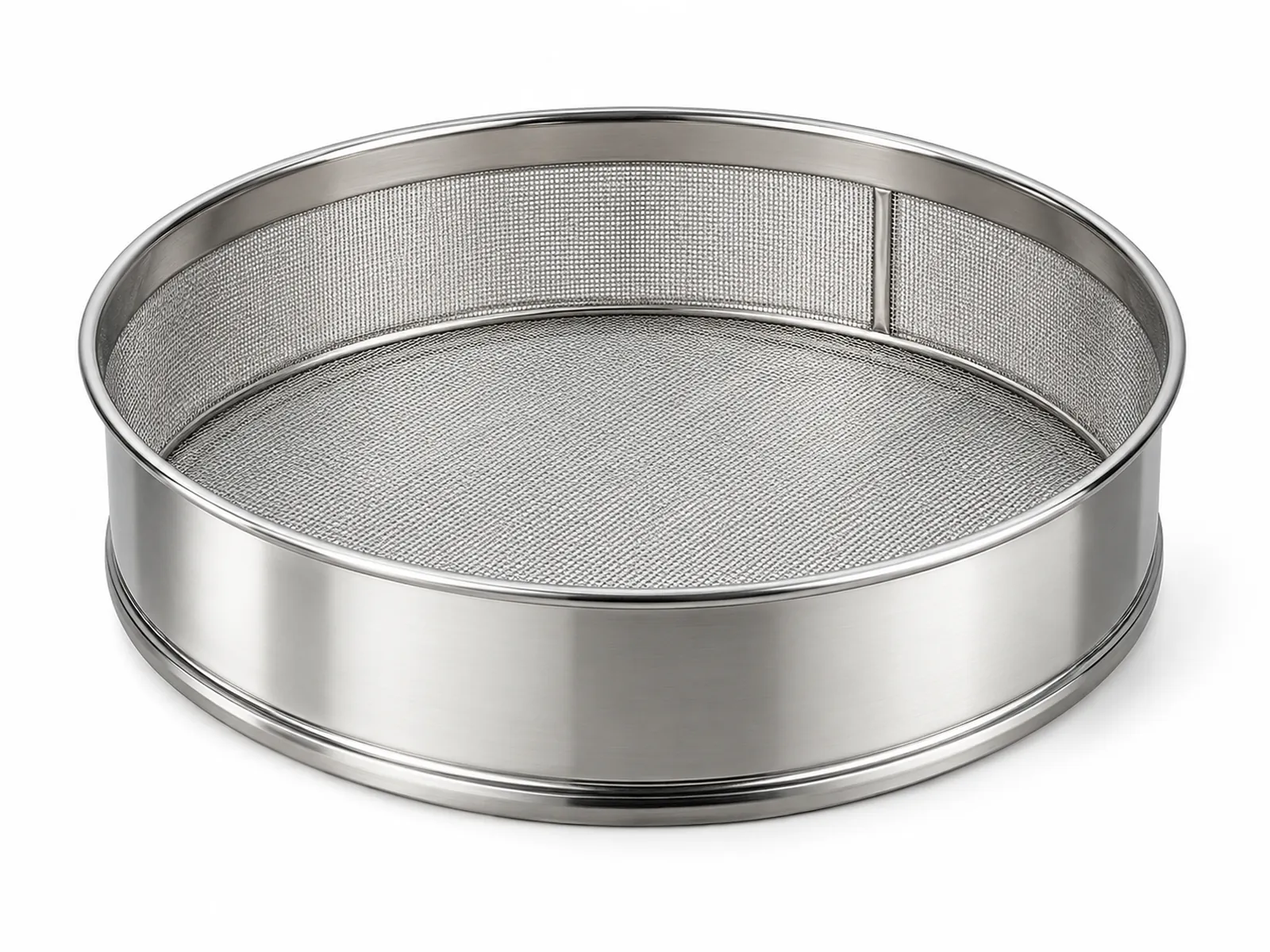 A round stainless steel drum flour sieve with fine woven mesh, flour falling through it into a ceramic mixing bowl, eggs