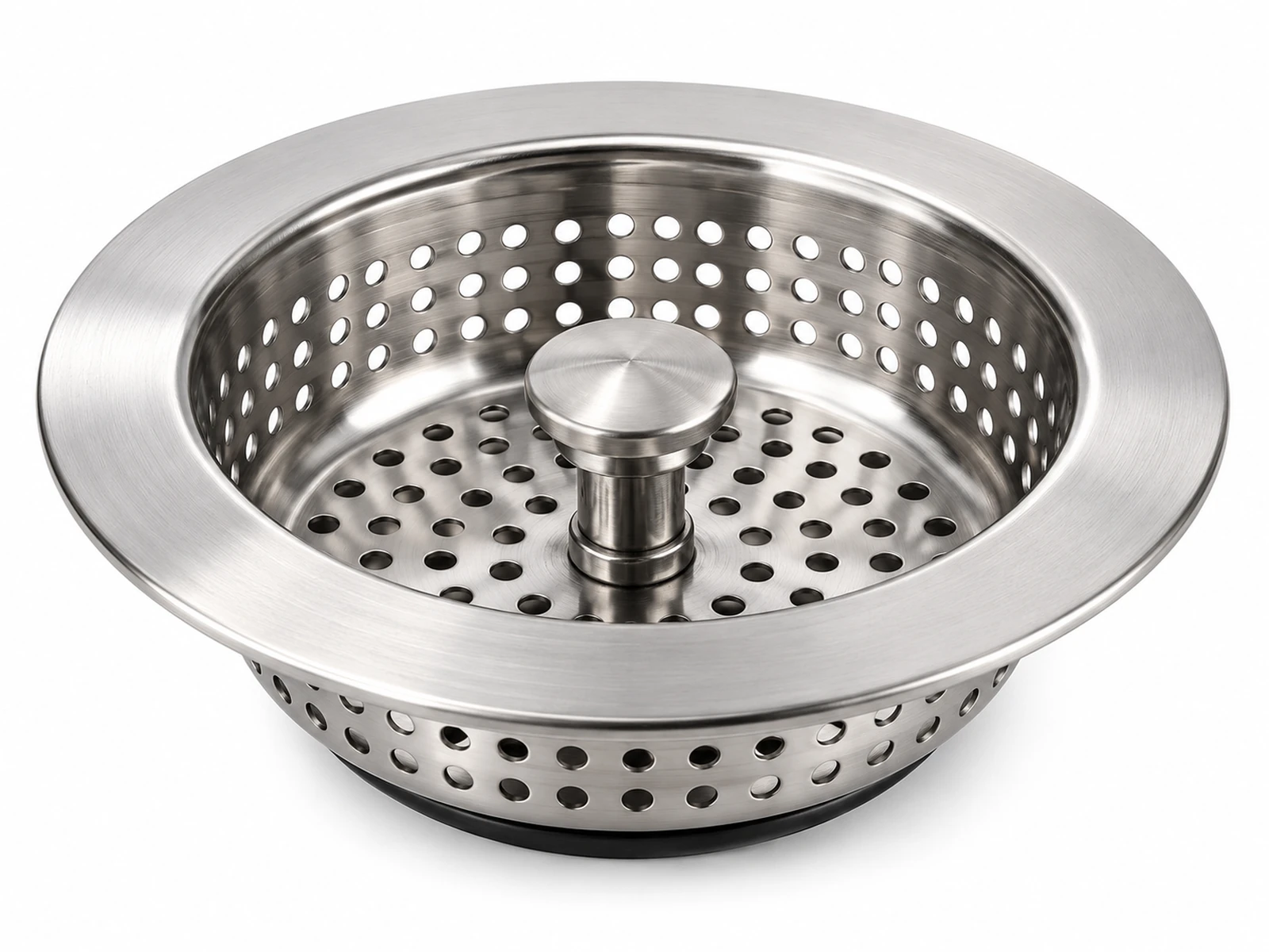 A stainless steel perforated kitchen sink strainer basket with central stopper knob sitting in a brushed steel sink
