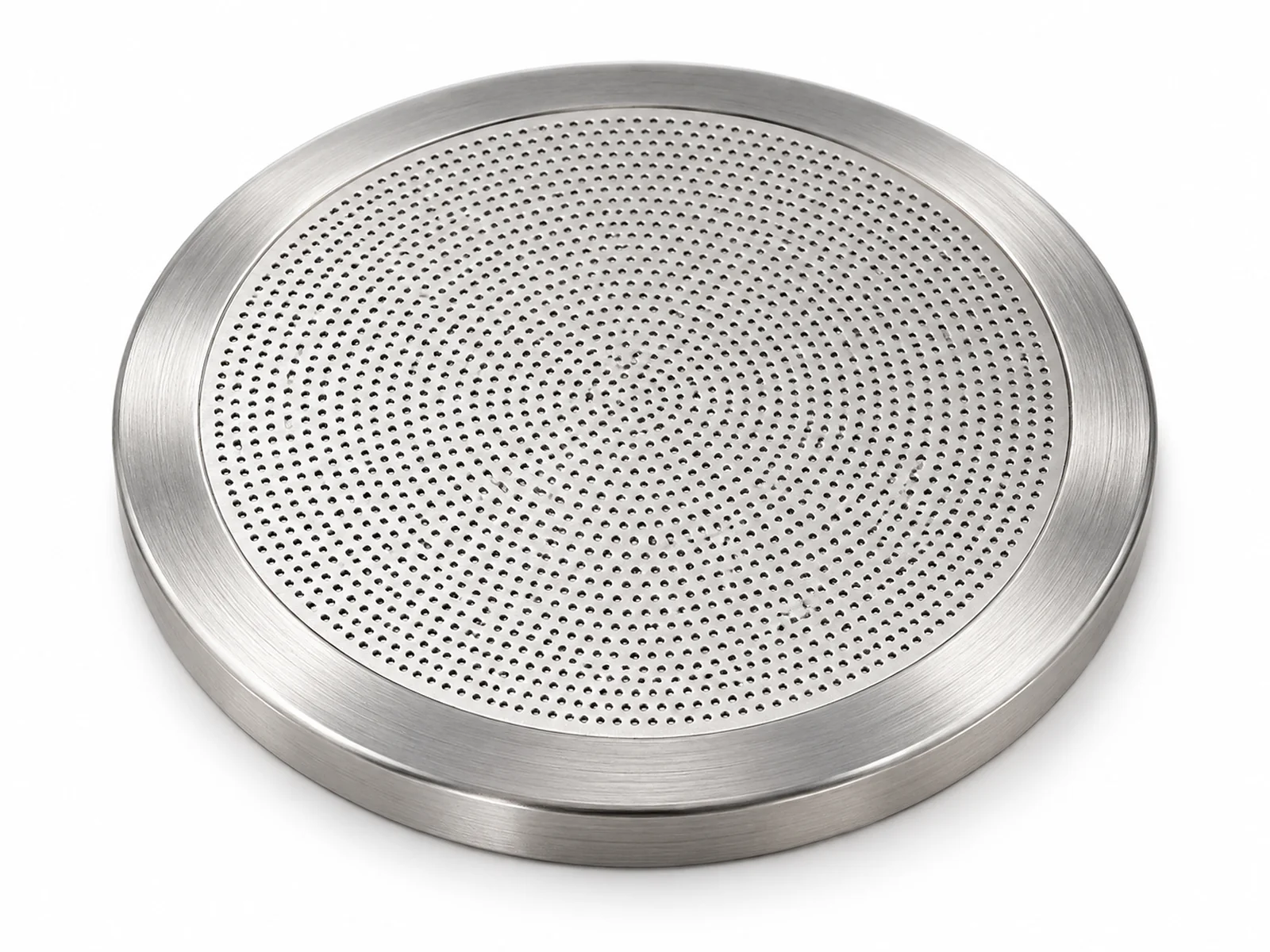 Extreme macro of a small stainless steel disc with a ring of microscopic laser-drilled holes, light passing through